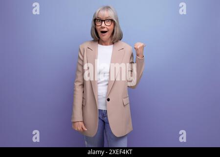 Preppy Fresh 60er Jahre Geschäftsfrau mittleren Alters in stilvollem Look auf hellem Studiohintergrund mit Kopierraum Stockfoto