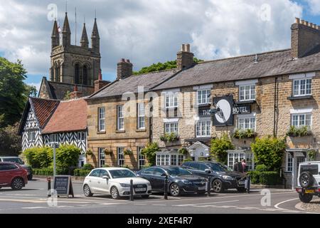 Blick auf den Marktplatz im Stadtzentrum von Helmsley, North Yorkshire, England, Großbritannien, mit dem Black Swan Hotel und dem Kirchturm Stockfoto