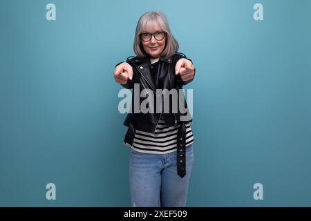 Erfolgreiche gesunde grauhaarige Frau 50er Großmutter Geschäftsfrau in einer Rockjacke auf einem hellen Hintergrund mit Kopierraum Stockfoto