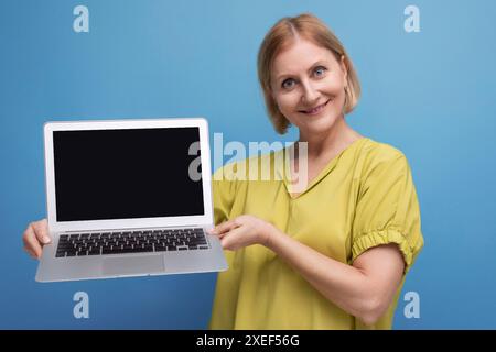Freudige Geschäftsreife Frau, die Laptoptechnik für den Fernberuf beherrscht Stockfoto