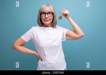 Schlüsselfertiges Geschäft mittleren Alters. Frau mit Immobilienschlüsseln Stockfoto