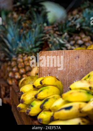 Auf einem Straßenmarkt in Havanna, Kuba, fängt eine Nahaufnahme einen leeren Papppreis ein, der auf Kreidemarkierungen inmitten von Stapeln reifer Früchte wartet. Stockfoto