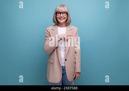 60s Frau mittleren Alters in einer stilvollen Laconjacke mit Studiohintergrund und Kopierbereich Stockfoto