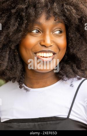 Strahlendes Lächeln einer jungen Schwarzen Frau mit natürlichem Haar Stockfoto