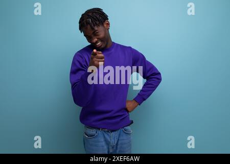 Nachdenklicher dunkelhäutiger afrikanischer junger Mann mit Dreadlocks in lässiger Kleidung Stockfoto