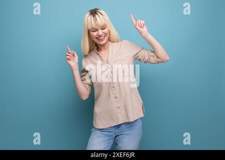 Fröhliche positive junge Frau im lässigen Look auf Studiohintergrund mit Kopierraum Stockfoto