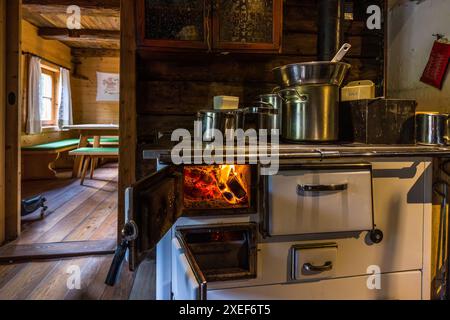 Alter Holzofen im sogenannten „Vorkaser“, dem traditionellen Wohn- und Arbeitsraum auf einer Almweide. Hausgemachte Köstlichkeiten auf der Filzmoosalm, Großarl, Salzburg, Österreich Stockfoto