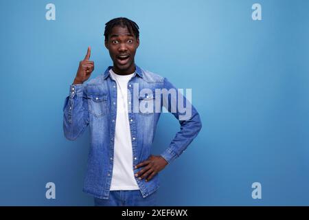 Ein eleganter, eleganter amerikanischer junger Mann mit Dreadlocks zeigt den Finger zur Seite Stockfoto