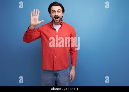 Der junge, starke, gutaussehende Kerl mit schwarzen Haaren ist selbstbewusst Stockfoto
