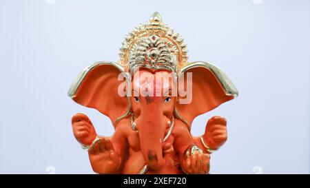 Wunderschönes Lord Ganesha Idol auf weißem Hintergrund. Orangefarbene Ganpati-Murti-Statue Stockfoto