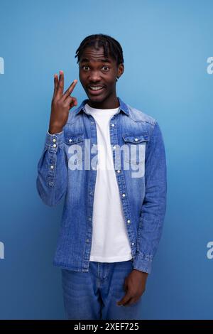 Intelligenter afrikanischer Mann mit Dreadlocks auf blauem Hintergrund Stockfoto