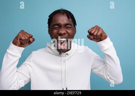 Süßer überraschter afrikanischer 20er-Mann mit Dreadlocks auf Hintergrund mit Kopierraum Stockfoto