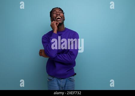 Nachdenklicher dunkelhäutiger afrikanischer junger Mann mit Dreadlocks in lässiger Kleidung Stockfoto