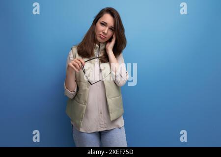 Müde junge Brünette Frau im Alltagsstress durch Brillentragen Stockfoto