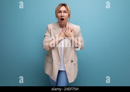 Porträt einer überraschten blonden jungen Frau in stilvollem, elegantem Look im Studio mit Kopierraum Stockfoto