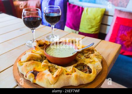 Traditioneller georgianischer adjara-Kuchen und Wein Stockfoto