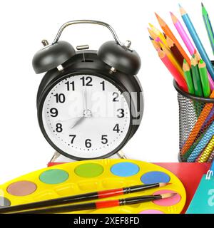Wecker, Satz Buntstifte und Aquarellfarben isoliert auf weißem Hintergrund. Das Konzept ist Zeit für Kreativität. Stockfoto