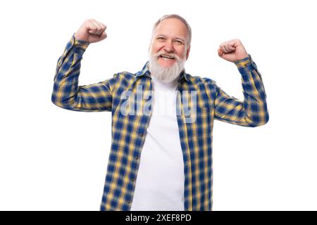Gesunder, starker Seniorenpensionär, grauhaariger Mann mit einem Bart in einem Hemd auf weißem Hintergrund Stockfoto