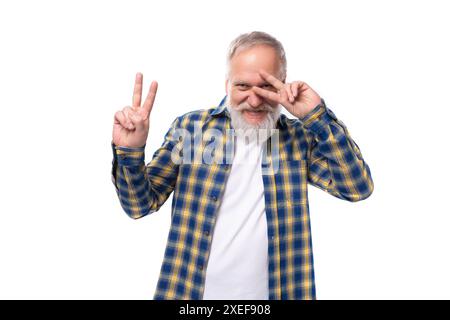 60s grauhaariger Mann mittleren Alters mit Bart im Hemd macht ein Gesicht auf weißem Hintergrund Stockfoto