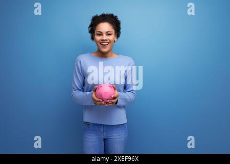 Die hübsche junge Latina Brünette hat Spargelder in einer Sparkasse Stockfoto