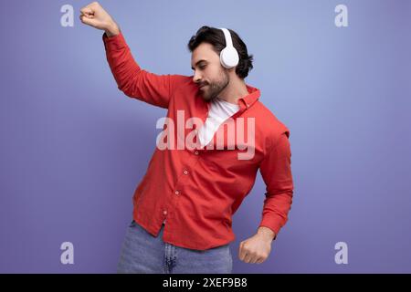Niedlicher kaukasier, junger Musikfreund in Kopfhörern, die tanzen Stockfoto