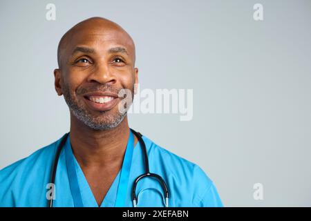 Close Up Studio Porträt Aufnahme Des Lächelnden Reifen Doktors, Der Peaks Vor Weißem Hintergrund Trägt Stockfoto