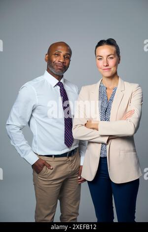Studio-Porträt Eines Seriösen Geschäftsmannes Und Einer Geschäftsfrau In Anzügen Vor Weißem Hintergrund Stockfoto