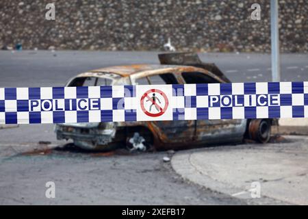 Auto verbrannt von einem Pyrenäen mit einem Polizeiband, auf dem auf Englisch "Polizei" geschrieben ist. Stockfoto