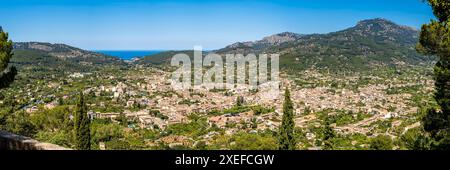 Ein weitläufiges Panorama, das den Charme der Stadt Sóller einfängt, erstreckt sich bis zum Port de Sóller und dem riesigen Mittelmeer, eingebettet in ein üppiges Tal. Stockfoto