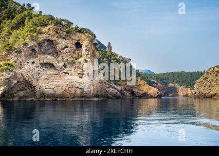 Überlagerte Kalksteinklippe an der Küste Mallorcas, die die zerklüftete Schönheit der Gegend von Morro de Sant Joan mit Blick auf den es Penyal Bernat de S'Illeta Rock zeigt. Stockfoto