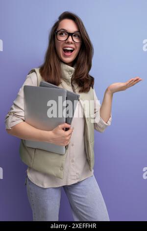 Selbstbewusste Büroangestellte aus den 30er Jahren mit einem Stapel Dokumente und einem Laptop in der Hand Stockfoto