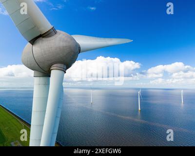 Eine Luftperspektive fängt die anmutige Bewegung einer Windenergieanlage ein, die hoch in der Weite des Ozeans steht Stockfoto