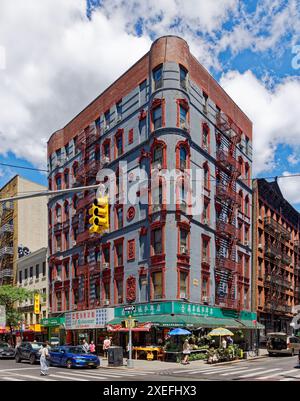 NYC Chinatown: 218 Grand Street, ein siebenstöckiges, begehbares Apartmentgebäude mit Türmchen; grau lackierte Ziegelsteine mit roter Terrakotta-Dekoration. Stockfoto