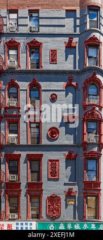 NYC Chinatown: 218 Grand Street, ein siebenstöckiges, begehbares Apartmentgebäude mit Türmchen; grau lackierte Ziegelsteine mit roter Terrakotta-Dekoration. Stockfoto