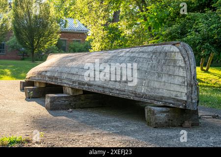 Altes, verwittertes, graues hölzernes Ruderboot auf dem Kopf, umgedreht, auf Blöcken. Stockfoto