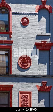 NYC Chinatown: 218 Grand Street, ein siebenstöckiges, begehbares Apartmentgebäude mit Türmchen; grau lackierte Ziegelsteine mit roter Terrakotta-Dekoration. Stockfoto