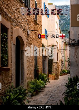 Dekorierte Gasse in Sóller mit Topfpflanzen und Girlanden mit dem Aufdruck „Sóller Firó“ für das Piratenfest Firó de Sóller, das einen historischen Sieg feiert. Stockfoto