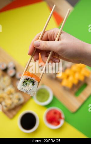 Sushi-Lieferung. Satz Rollen in einer Einwegverpackung auf schwarzem Hintergrund. Draufsicht Stockfoto