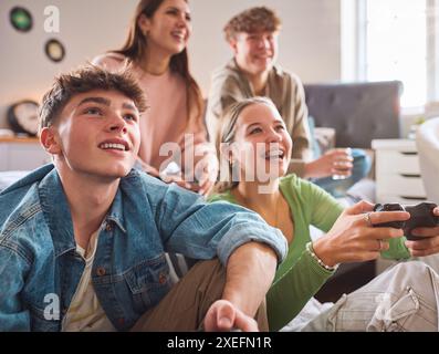 Nahaufnahme Von Mädchen Und Jungen Im Teenageralter Zu Hause Im Schlafzimmer, Die Gemeinsam Computerspiele Spielen Stockfoto