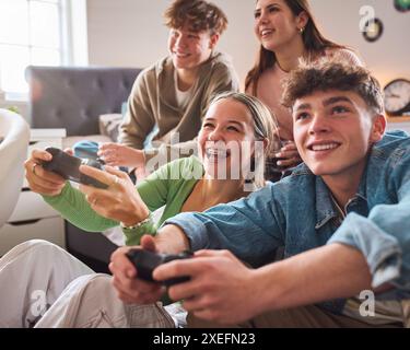 Nahaufnahme Von Mädchen Und Jungen Im Teenageralter Zu Hause Im Schlafzimmer, Die Gemeinsam Computerspiele Spielen Stockfoto