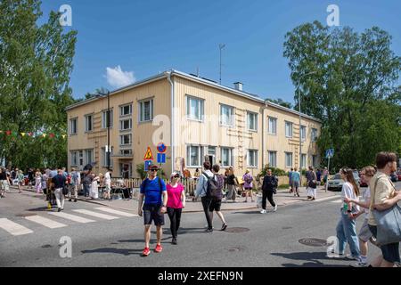 Menschen, die die Straße überqueren, können beim Kumpulan kyläjuhlat oder der Kumpula Village Party, einer Straßenmesse im Stadtteil Kumpula in Helsinki, Finnland, teilnehmen Stockfoto