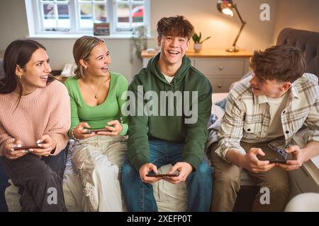 Gruppe Von Jugendlichen Mädchen Und Jungen Zu Hause Im Schlafzimmer Gemeinsam Gaming Auf Mobiltelefonen Stockfoto