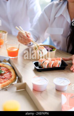 Sushi Roll Philadelphia mit Lachs, geräucherter Aal, Avocado, Frischkäse auf schwarzem Hintergrund. Sushi Menü. Japanisches Essen. Stockfoto