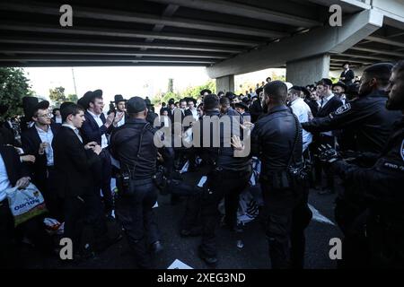 Orthodoxe Juden blockieren Highway gegen Wehrpflicht in Isra BNEI BRAK, ISRAEL - 27. JUNI: Dutzende ultraorthodoxe Juden, auch bekannt als Haredim, stoßen am 27. Juni 2024 mit der israelischen Polizei zusammen, während sie einen Sit-in-Protest gegen den Militärdienst auf der Autobahn in Bnei Brak, Israel, veranstalten. Foto: saeed qaq Copyright: XSAEEDQAQx image00015.jpeg Stockfoto