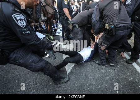 Orthodoxe Juden blockieren Highway gegen Wehrpflicht in Isra BNEI BRAK, ISRAEL - 27. JUNI: Dutzende ultraorthodoxe Juden, auch bekannt als Haredim, stoßen am 27. Juni 2024 mit der israelischen Polizei zusammen, während sie einen Sit-in-Protest gegen den Militärdienst auf der Autobahn in Bnei Brak, Israel, veranstalten. Foto: saeed qaq Copyright: XSAEEDQAQx image00006.jpeg Stockfoto