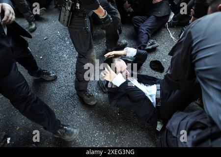 Orthodoxe Juden blockieren Highway gegen Wehrpflicht in Isra BNEI BRAK, ISRAEL - 27. JUNI: Dutzende ultraorthodoxe Juden, auch bekannt als Haredim, stoßen am 27. Juni 2024 mit der israelischen Polizei zusammen, während sie einen Sit-in-Protest gegen den Militärdienst auf der Autobahn in Bnei Brak, Israel, veranstalten. Foto: saeed qaq Copyright: XSAEEDQAQx image00010.jpeg Stockfoto