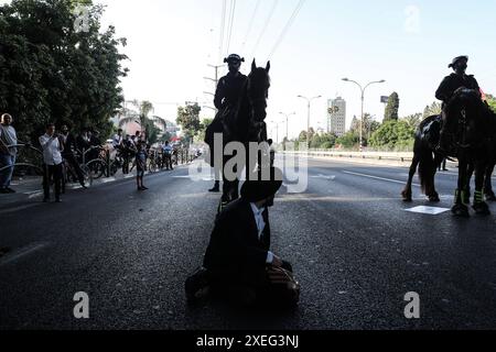 Orthodoxe Juden blockieren Highway gegen Wehrpflicht in Isra BNEI BRAK, ISRAEL - 27. JUNI: Dutzende ultraorthodoxe Juden, auch bekannt als Haredim, stoßen am 27. Juni 2024 mit der israelischen Polizei zusammen, während sie einen Sit-in-Protest gegen den Militärdienst auf der Autobahn in Bnei Brak, Israel, veranstalten. Foto: saeed qaq Copyright: XSAEEDQAQx image00016.jpeg Stockfoto