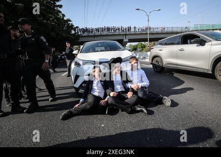 Orthodoxe Juden blockieren Highway gegen Wehrpflicht in Isra BNEI BRAK, ISRAEL - 27. JUNI: Dutzende ultraorthodoxe Juden, auch bekannt als Haredim, stoßen am 27. Juni 2024 mit der israelischen Polizei zusammen, während sie einen Sit-in-Protest gegen den Militärdienst auf der Autobahn in Bnei Brak, Israel, veranstalten. Foto: saeed qaq Copyright: XSAEEDQAQx image00001.jpeg Stockfoto