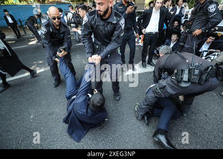 Orthodoxe Juden blockieren Highway gegen Wehrpflicht in Isra BNEI BRAK, ISRAEL - 27. JUNI: Dutzende ultraorthodoxe Juden, auch bekannt als Haredim, stoßen am 27. Juni 2024 mit der israelischen Polizei zusammen, während sie einen Sit-in-Protest gegen den Militärdienst auf der Autobahn in Bnei Brak, Israel, veranstalten. Foto: saeed qaq Copyright: XSAEEDQAQx image00002.jpeg Stockfoto