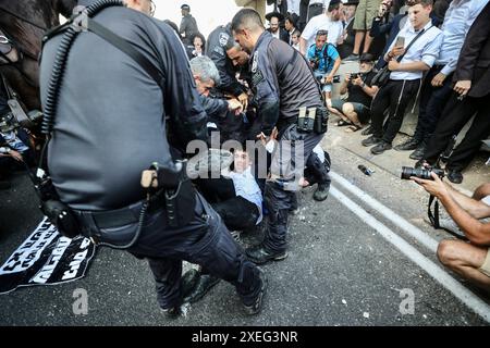 Orthodoxe Juden blockieren Highway gegen Wehrpflicht in Isra BNEI BRAK, ISRAEL - 27. JUNI: Dutzende ultraorthodoxe Juden, auch bekannt als Haredim, stoßen am 27. Juni 2024 mit der israelischen Polizei zusammen, während sie einen Sit-in-Protest gegen den Militärdienst auf der Autobahn in Bnei Brak, Israel, veranstalten. Foto: saeed qaq Copyright: XSAEEDQAQx image00007.jpeg Stockfoto